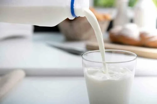 বোতল থেকে গ্লাসে দুধ ঢালা হচ্ছে